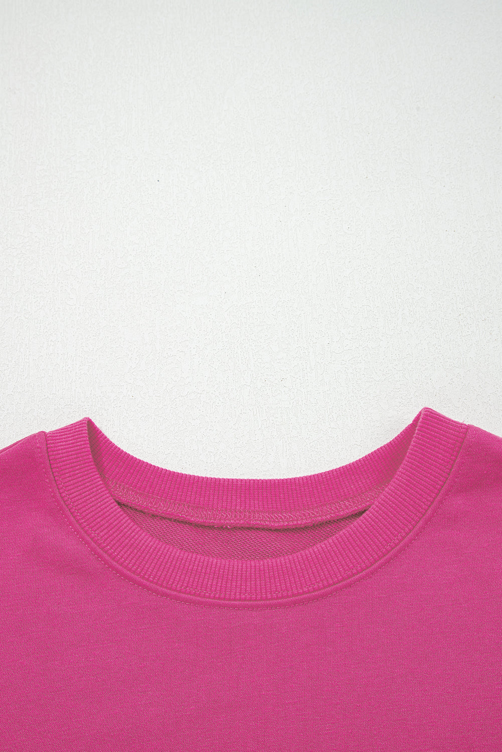 Rosarotes Oversize-Sweatshirt mit Collegestreifen und überschnittenen Schultern.