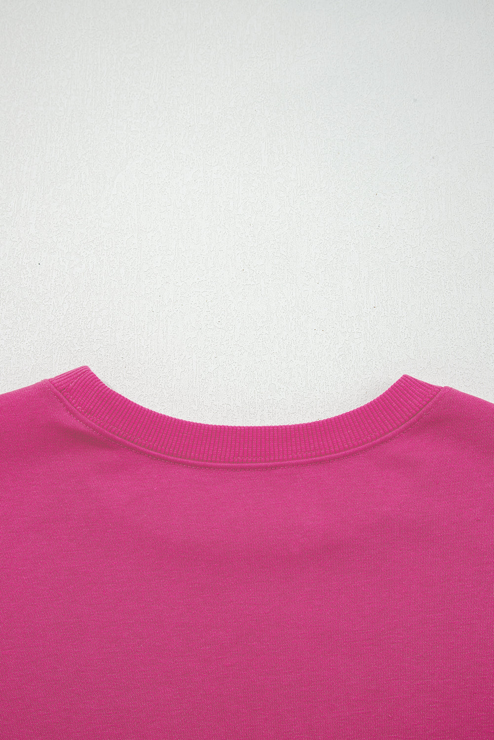 Rosarotes Oversize-Sweatshirt mit Collegestreifen und überschnittenen Schultern.